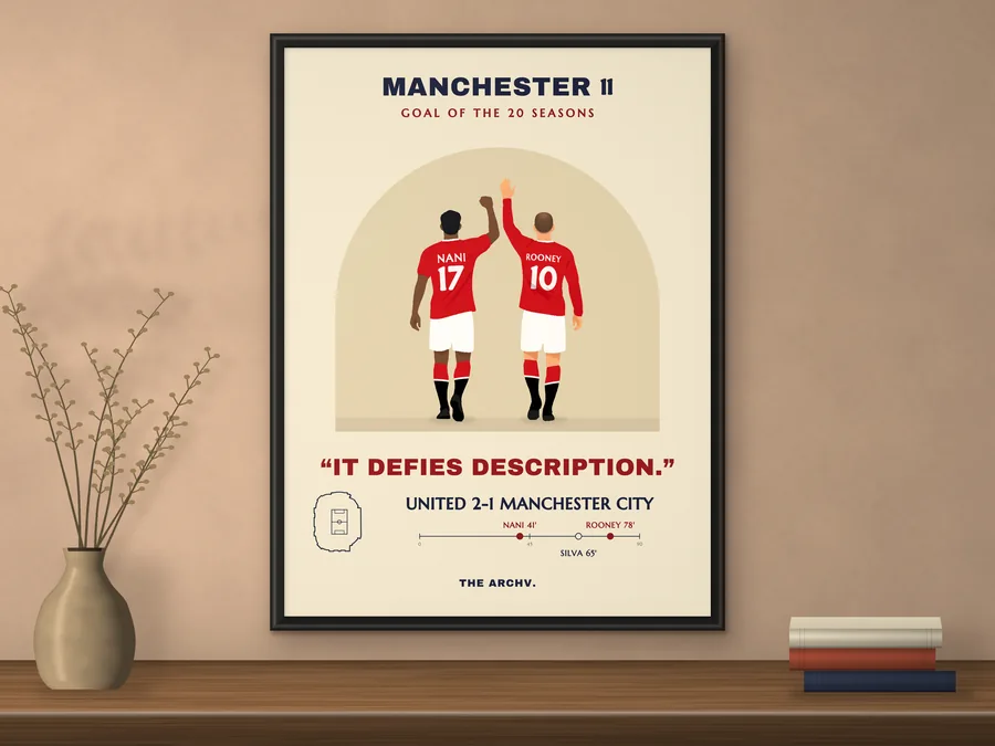 Framed poster of Manchester United 2-1 Manchester City, the February 2011 derby at Old Trafford, hanging on a wall.