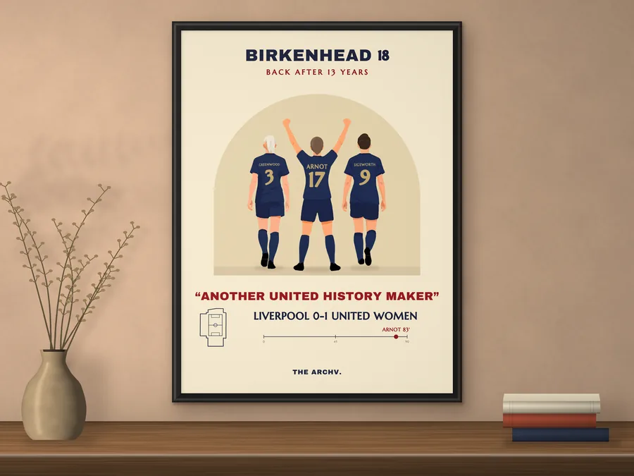 Framed poster on a wall: Manchester United Women's 1-0 win over Liverpool in Birkenhead, 2018, three players seen from behind in navy and gold.