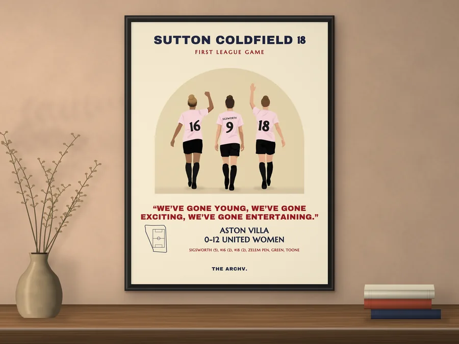 Framed poster on a wall: Manchester United Women's 12-0 win at Aston Villa, Sutton Coldfield 2018, three players seen from behind in pink shirts.